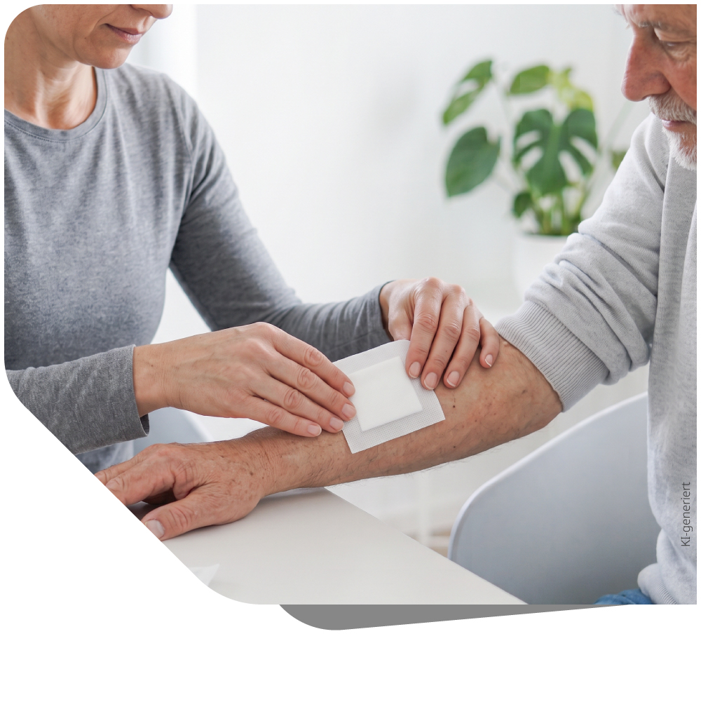 Eine Pflegefachkraft versorgt eine Wunde an der Hand eines Patienten. Symbolisiert professionelles Wundmanagement und Verbandwechsel in der häuslichen Pflege.